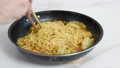 Man eating ramen noodles with eggs and dumplings 99517657